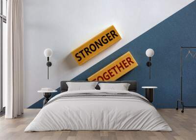 Stronger together symbol. Concept words 'stronger together' on wooden blocks on a beautiful white and blue background. Business, motivational and stronger together concept. Wall mural