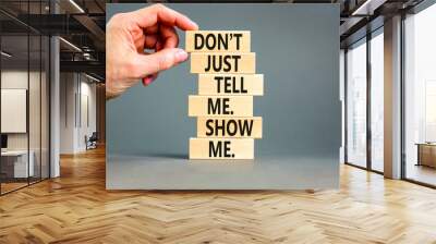 Tell or show symbol. Concept words Do not just tell me, show me on wooden blocks. Beautiful grey table grey background. Businessman hand. Business tell or show concept. Copy space. Wall mural