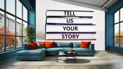 Tell us your story symbol. Books with words 'Tell us your story'. Businessman hand. Beautiful white background, copy space. Business, storytelling and tell us your story concept. Wall mural