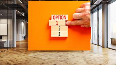 Time to option 1 symbol. Concept word Option 1 2 3 on wooden block. Businessman hand. Beautiful orange table orange background. Business planning and time to option 1 concept. Copy space. Wall mural