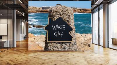 Wage gap symbol. Concept words Wage gap on wooden blocks on a beautiful black chalk blackboard on a beautiful beach stone blue sea background. Business, support and wage gap concept. Copy space. Wall mural