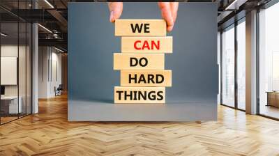 We can do hard things symbol. Concept words We can do hard things on wooden blocks. Beautiful grey table grey background. Businessman hand. Business, we can do hard things concept. Copy space. Wall mural