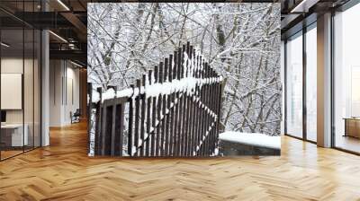 An old forged fence in the snow after a snowfall Wall mural