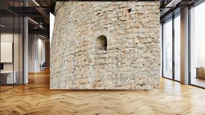 Part of the wall of an ancient stone fortress with a window for shooting Wall mural