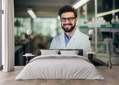 Young man with beard wearing white lab coat and glasses working at scientist laboratory happy face smiling confident with crossed arms looking at the camera. Wall mural