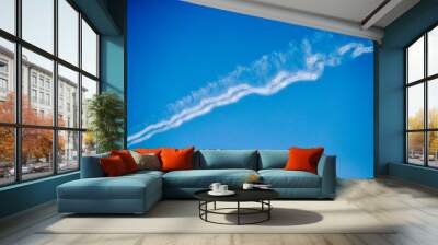 White contrails on a blue sky, wake vortex and vortices of an aeroplane Wall mural