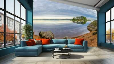 Stones on the shore and island with pine forest in beautiful fresh blue lake, Park Mon Repos, Vyborg, Russia Wall mural