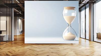 A sand timer is sitting on a table. The sand is almost gone, and the timer is almost empty. Concept of time passing quickly and the importance of making the most of the time we have Wall mural