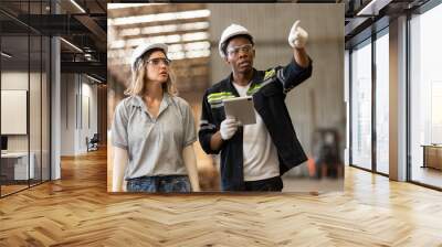 Team engineer manager wooden factory wearing safety uniform and hard hat working using tablet checking quality of wooden products furniture at workshop. Diverse ethnic worker hardwood warehouse. Wall mural