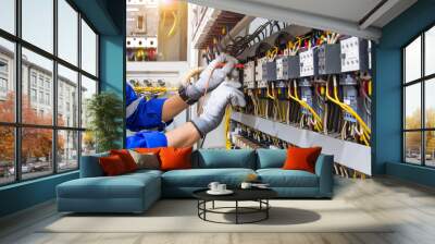 Electricity or electrical maintenance service, Engineer hand checking electric current voltage at circuit breaker terminal and cable wiring check in main power load center distribution board. Wall mural