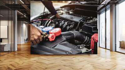 Technician auto mechanic use measuring manifold gauge for filling car air conditioner for fix and checking for repair maintenance and check refrigerant during car periodic inspection service Wall mural