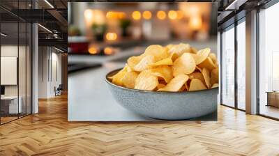 A delicious bowl of crispy potato chips, perfect for snacking or sharing at gatherings, set in a warm kitchen atmosphere. Wall mural