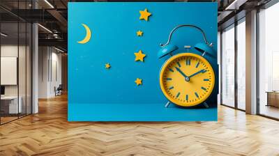 A vibrant alarm clock sits against a blue backdrop adorned with stars and a moon, symbolizing the passage of time and dreams. Wall mural