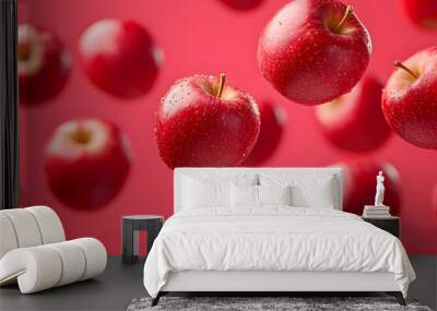 Fresh red apples floating in the air, showcasing vibrant colors against a smooth red background. Perfect for food-themed designs. Wall mural