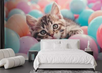 a cute kitten laying comforably in pastel color ball pits, cute smile Wall mural