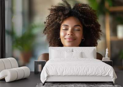 Woman with curly hair enjoying a moment of relaxation inside a bright, green-filled room. A peaceful expression on her face. Wall mural