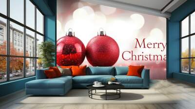 Two red balls with Merry Christmas text on bokeh background with lights. Xmas and New Year greeting card holiday theme Wall mural