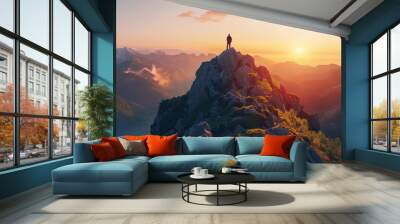 A person standing on top of a mountain at sunset. Wall mural