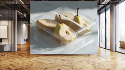 A plastic container with two pears in it. The pears are cut in half and are sitting on top of a white marble counter Wall mural