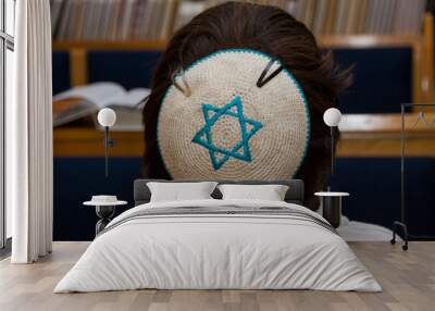 A rear view of praying young man with star of david, magen david, yarmulke Wall mural