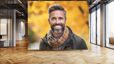 Portrait of a handsome mature man smiling at the camera in an autumn park Wall mural