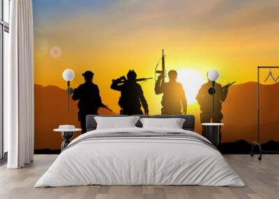 Silhouettes of soldiers against the sunset. Military background. EPS10 vector Wall mural