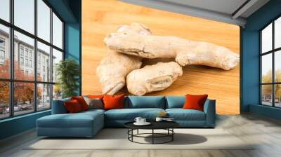 Whole ginger root isolated on a wood background Wall mural