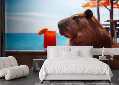 The science of relaxing and enjoying life, a capybara with a cocktail sitting at a table in a cafe and enjoying relaxation Wall mural