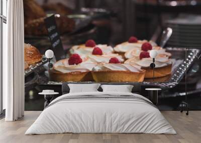 Cakes with whipped cream and raspberries in a pastry shop. Wall mural