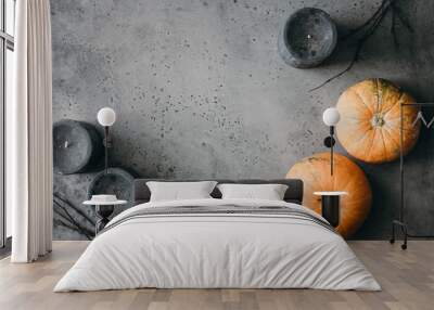 Halloween background, still life flat lay composition of black candles, small pumpkins, dried branches over grey. Top view, place for text. Wall mural