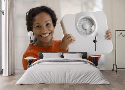 Happy Black woman holding scale Wall mural