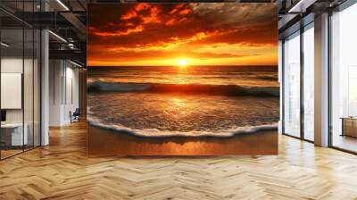 A beautiful sunset over the ocean, with waves crashing on the sandy shore. Wall mural