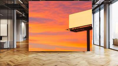 Blank billboard against vibrant orange sunset sky. Wall mural