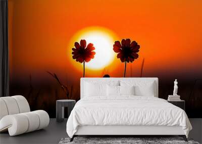 Silhouette of two flowers against a vibrant orange sunset. Wall mural