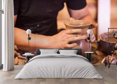 Close-up of hands making pottery on a wheel Wall mural