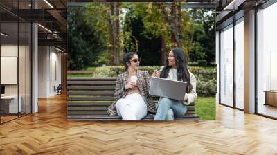 couple latin and caucasian girls with computer Wall mural