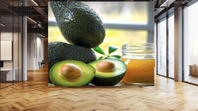 a close-up of ripe avocados on a table with a jar of honey in the background, suggesting a healthy snack. Wall mural