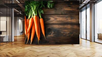 Fresh organic carrots with green tops placed on wooden background Wall mural