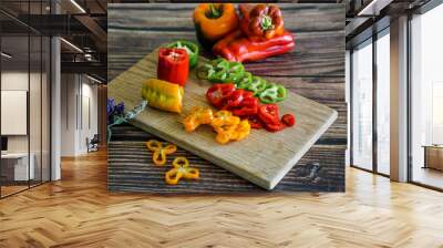 Home grown sweet bell peppers in the kitchen, slicing and preparing salad  Wall mural