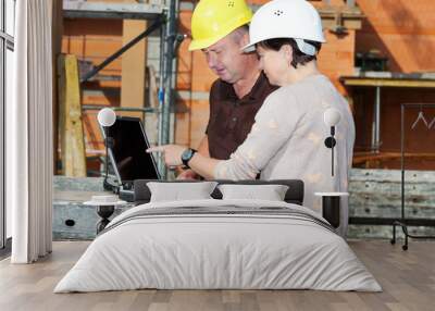 civil engineer and construction worker looking at the laptop Wall mural