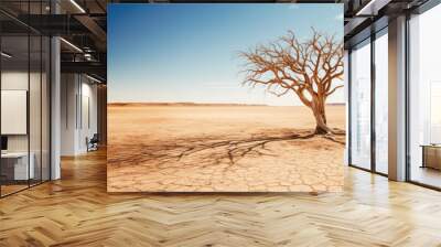 A desolate desert landscape featuring a dead tree standing tall against the barren backdrop, symbolizing the arid conditions. Wall mural