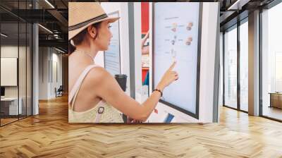 a female customer uses a touchscreen terminal or self-service kiosk to order at a fast food restaura Wall mural