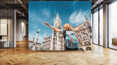 A girl tourist traveler enjoys a Grand view of the Gothic building of the Old town Hall in Munich. Sightseeing and exploration of Germany concept Wall mural