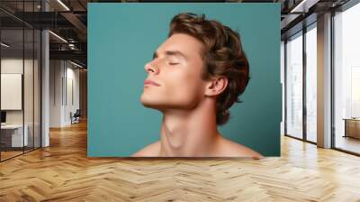 A sexy and healthy young man, with a closeup focus on his head and chin, exudes a serious yet attractive expression, emphasizing the care and attention to detail in his appearance. Wall mural