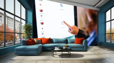 A woman orders food in the touch screen terminal in the electronic menu in the restaurant Wall mural