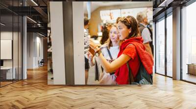 A woman orders food in the touch screen terminal with electronic menu in fast food restaurant Wall mural