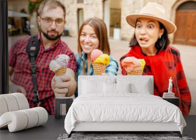 Happy group of friends eating ice-cream in old town center in Italy, travel and food concept Wall mural