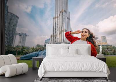 happy student girl lying on a grass and enjoying incredible view in Dubai, UAE Wall mural