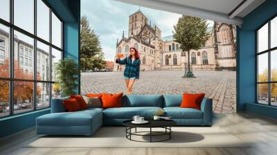 Happy tourist girl taking selfie photo while visiting St. Paulus Dom Cathedral and admiring old town architecture buildings in Munster, Germany Wall mural