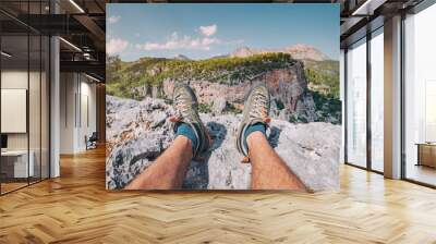 Hiker legs with trekking shoes on top of the canyon cliff. Outdoors activity and skyrunning concept Wall mural